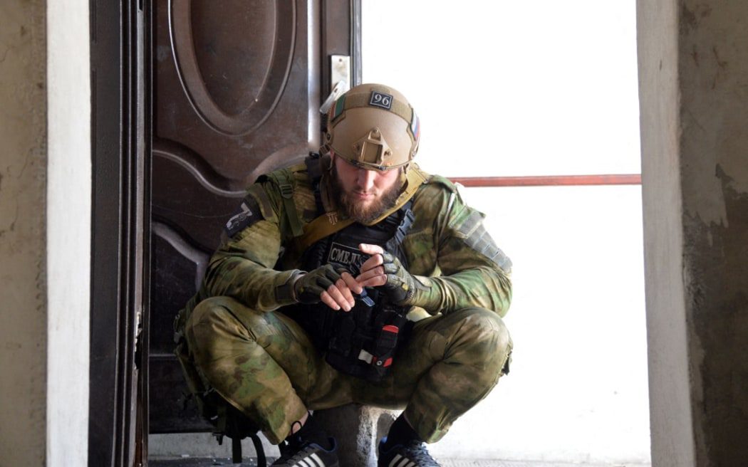Żołnierz Specjalistycznego Pułku Policji Achmad Kadyrow w kościele św. Jerzego na osiedlu Komichovakha w Ługańsku.  Siły rosyjskie posuwają się obecnie do przodu w regionie.