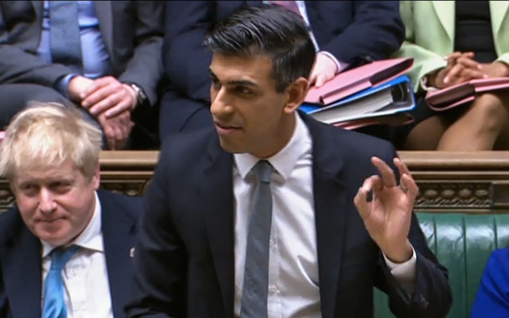 Klip z wideo transmitowanego przez Wydział Rejestracji Parlamentarnej Parlamentu Wielkiej Brytanii (PRU) pokazuje brytyjskiego kanclerza skarbu Rishi Sunaka wskazującego, że przedstawia parlamentarzystom wiosenne zestawienie budżetowe.