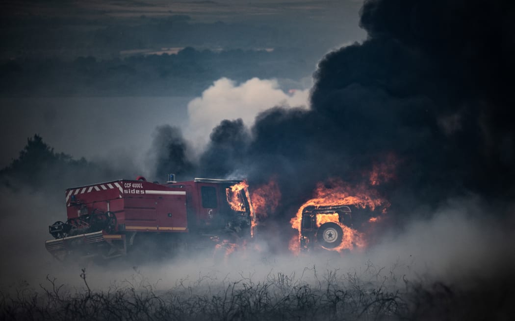 Wozy strażackie płoną w pożarze w Mont-Darys, niedaleko Brassarts w zachodniej Francji, 19 lipca 2022 r.
